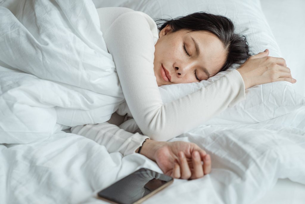 Fit woman sleeping in bed